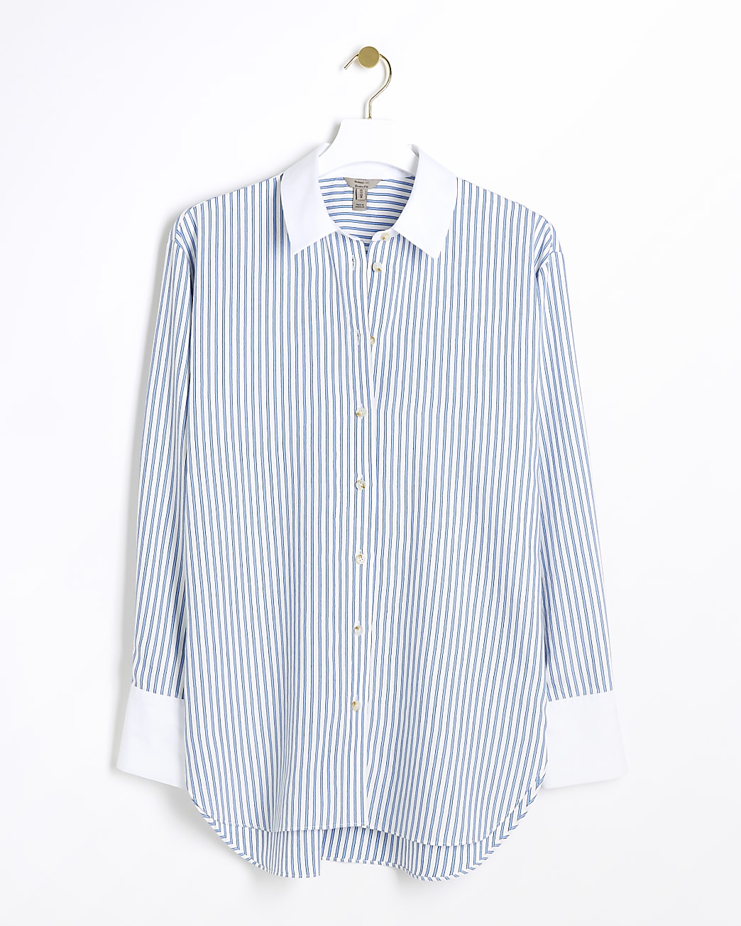 An oversized striped shirt from River Island hanging on a gold-toned hanger against a white background. The shirt has vertical blue and white stripes with a crisp white collar and cuffs for a classic contrast. It features a full button placket with golden buttons, a curved hem, and long sleeves, combining a timeless pattern with a modern, relaxed silhouette.